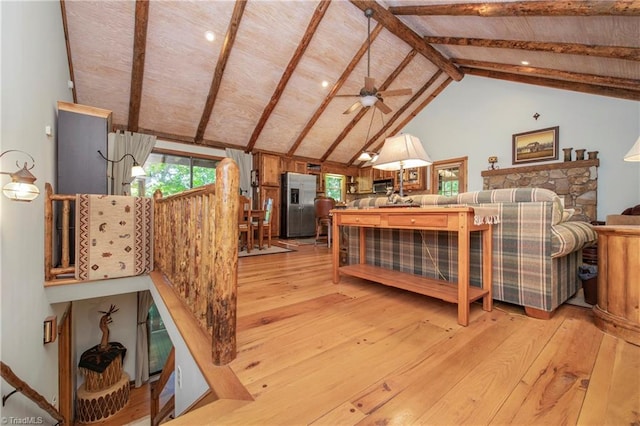 bedroom with light wood-type flooring, lofted ceiling with beams, and stainless steel fridge with ice dispenser