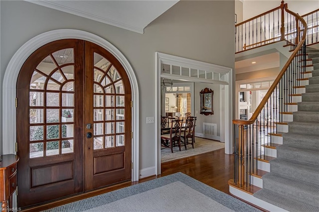 entrance foyer with french doors, dark hardwood / wood-style flooring, and ornamental molding