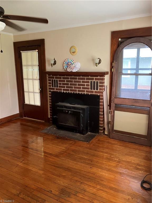 2096 Fancy Gap Rd, Mount Airy, NC 27030 - unfurnished living room featuring wood-type flooring, ornamental molding, ceiling fan, and baseboards