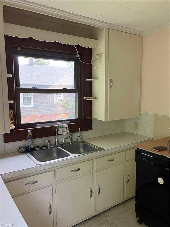 2096 Fancy Gap Rd, Mount Airy, NC 27030 - kitchen with dishwasher, light countertops, a sink, light tile patterned flooring, and crown molding