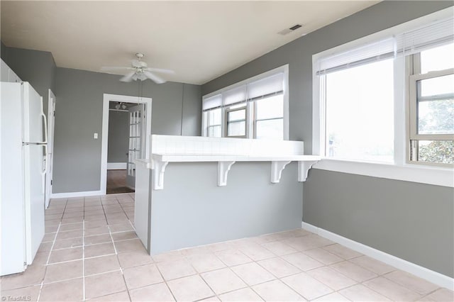1025 W End Blvd, Winston-Salem, NC 27101 - kitchen featuring ceiling fan, a breakfast bar, visible vents, tile countertops, and freestanding refrigerator
