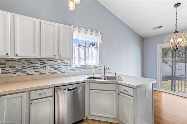 kitchen featuring visible vents, a sink, stainless steel dishwasher, decorative backsplash, and a chandelier