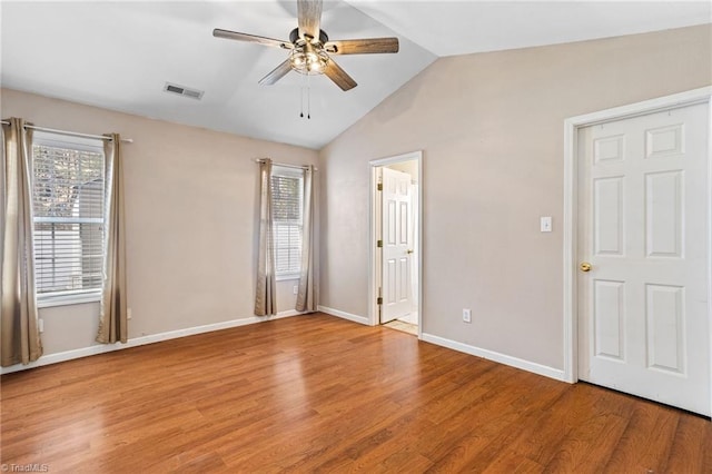 spare room with visible vents, a ceiling fan, baseboards, light wood finished floors, and lofted ceiling