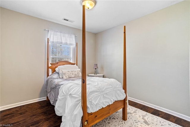 bedroom with visible vents, baseboards, and wood finished floors