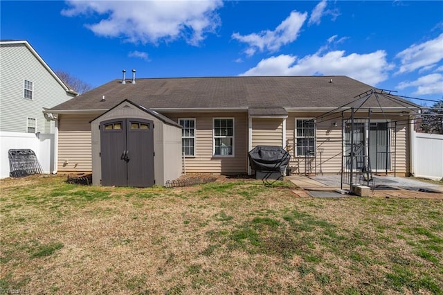 back of property featuring fence, a gazebo, a patio area, a storage unit, and an outbuilding