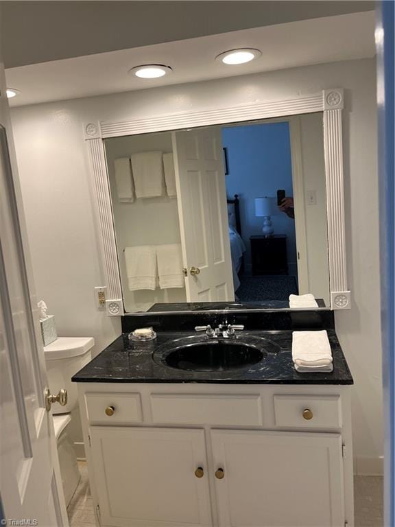 bathroom featuring tile patterned flooring, toilet, and vanity