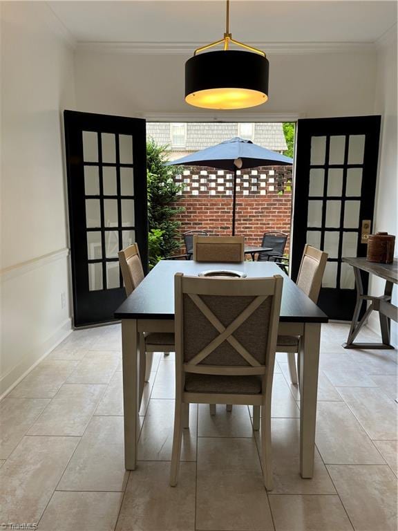 dining space featuring crown molding and light tile patterned floors