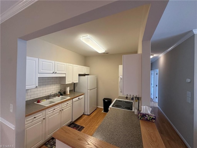 kitchen with light wood-style flooring, backsplash, white cabinetry, a sink, and white appliances