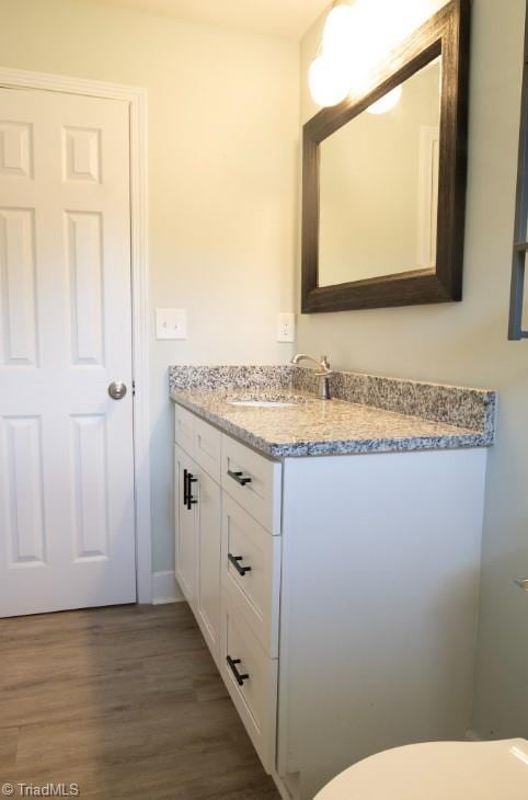 bathroom with vanity, hardwood / wood-style flooring, and toilet