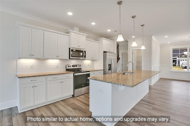 kitchen with stainless steel appliances, a sink, crown molding, white cabinetry, and light wood-style flooring