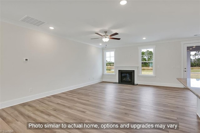 unfurnished living room with ornamental molding, recessed lighting, a ceiling fan, a glass covered fireplace, and wood finished floors