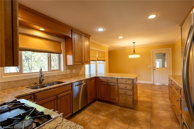 kitchen featuring decorative light fixtures, kitchen peninsula, sink, appliances with stainless steel finishes, and light stone countertops