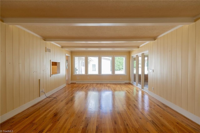 unfurnished room featuring baseboard heating, beamed ceiling, and light wood-type flooring