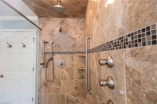 bathroom featuring tiled shower and crown molding