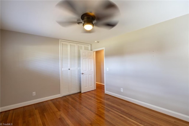 unfurnished bedroom featuring ceiling fan, hardwood / wood-style flooring, and a closet