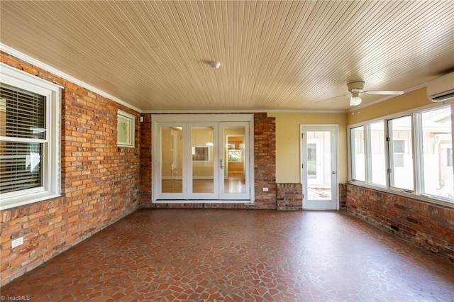 unfurnished sunroom with ceiling fan and a wall mounted air conditioner