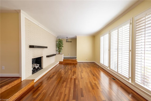 unfurnished living room featuring ornamental molding, a fireplace, and hardwood / wood-style floors