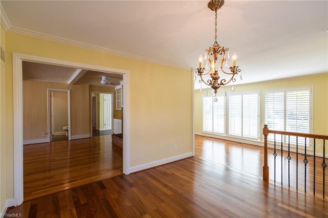 spare room featuring ornamental molding, dark hardwood / wood-style floors, and a notable chandelier