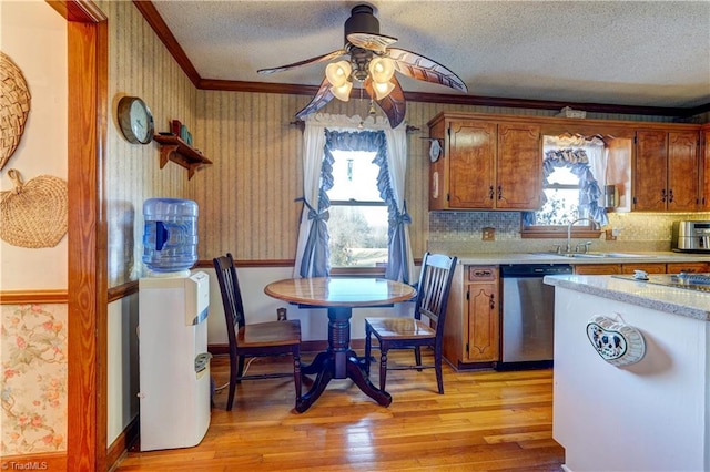 kitchen featuring ceiling fan, stainless steel dishwasher, a textured ceiling, and light hardwood / wood-style floors