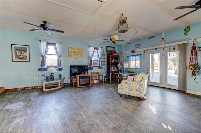 living area with radiator, dark wood-type flooring, and ceiling fan