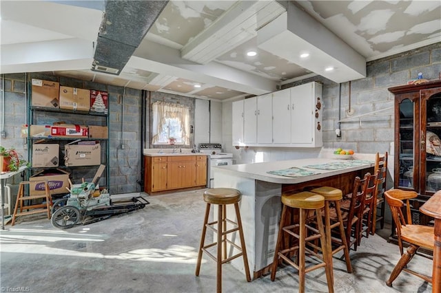 kitchen with sink, white electric range, kitchen peninsula, a breakfast bar, and white cabinets