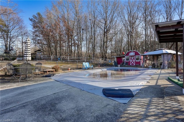 view of pool with a patio area and a shed