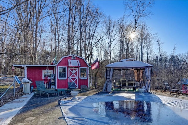 view of pool featuring a gazebo, a grill, and a shed