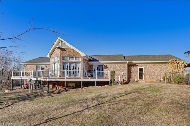 back of property with a wooden deck and a yard