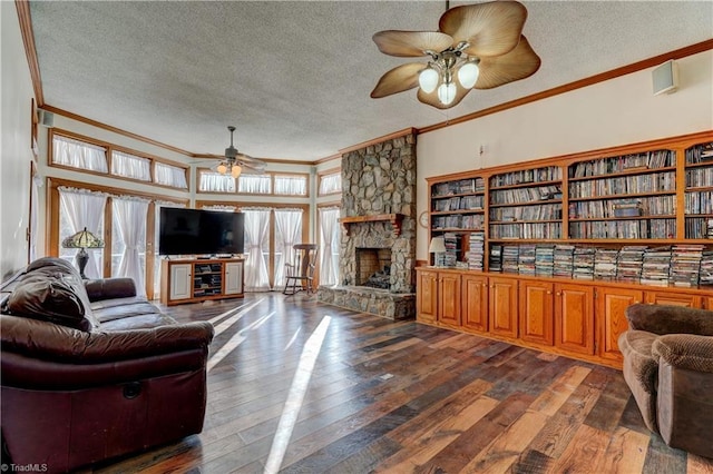 living room featuring dark hardwood / wood-style flooring, a fireplace, a textured ceiling, and ornamental molding