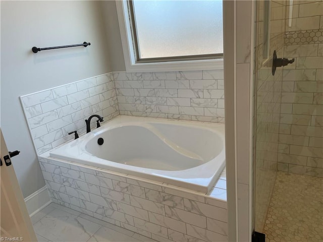 full bathroom featuring a garden tub, marble finish floor, and a shower stall