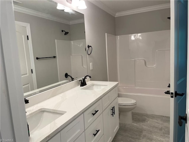 full bath featuring toilet, crown molding, washtub / shower combination, and a sink