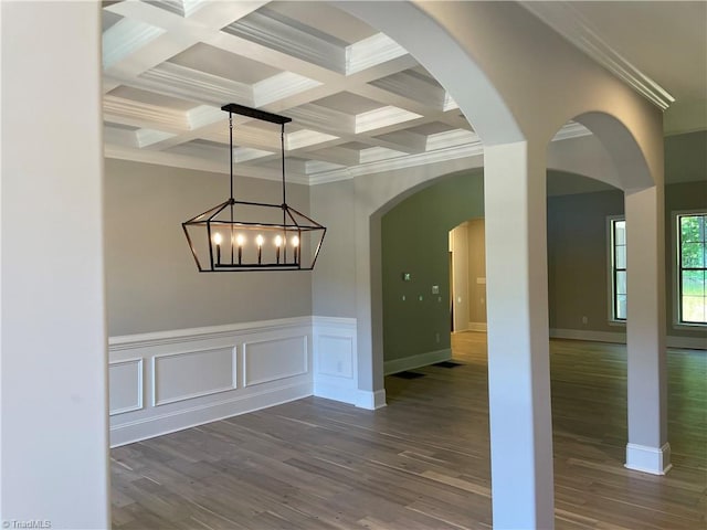 spare room featuring ornamental molding, dark wood-type flooring, beamed ceiling, and coffered ceiling