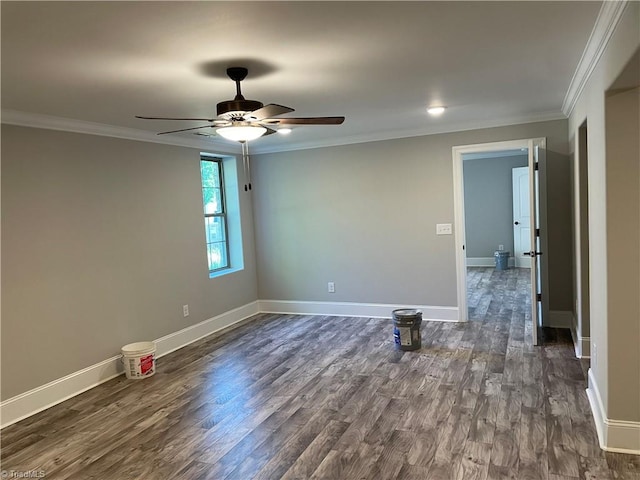 spare room featuring baseboards, ceiling fan, dark wood-type flooring, and crown molding