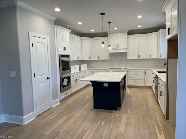 kitchen with ornamental molding, light wood-type flooring, a center island, and light countertops