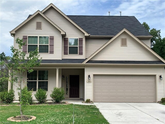2015 Ram Rd, Greensboro, NC 27405 - view of front of house with concrete driveway, a porch, a garage, and a front lawn