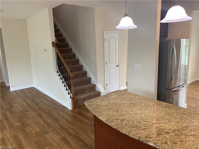 2015 Ram Rd, Greensboro, NC 27405 - kitchen with freestanding refrigerator, dark wood-style floors, light stone counters, and decorative light fixtures