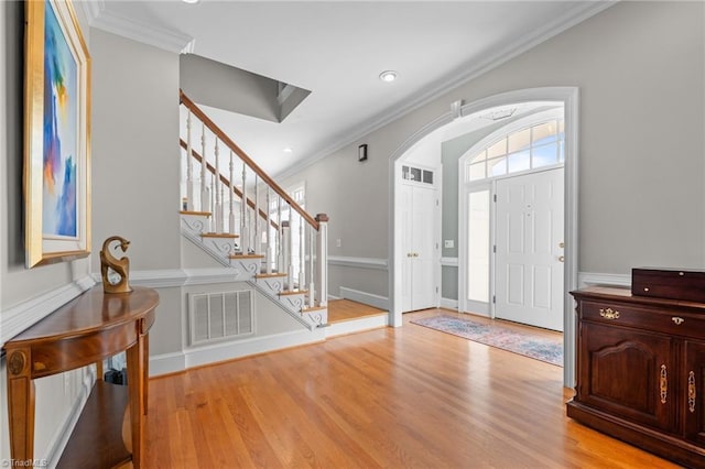 foyer with ornamental molding and light wood-type flooring