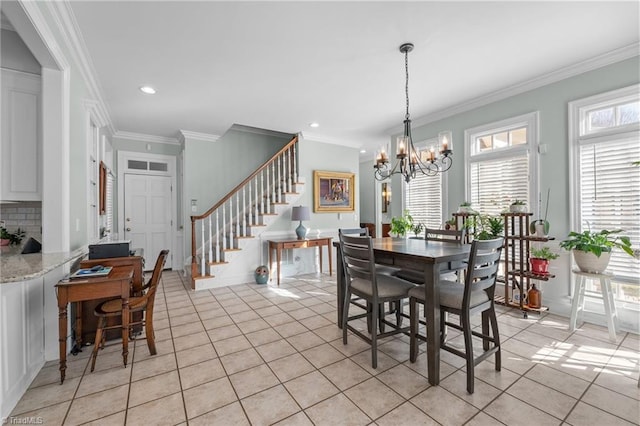 tiled dining space with crown molding and a chandelier