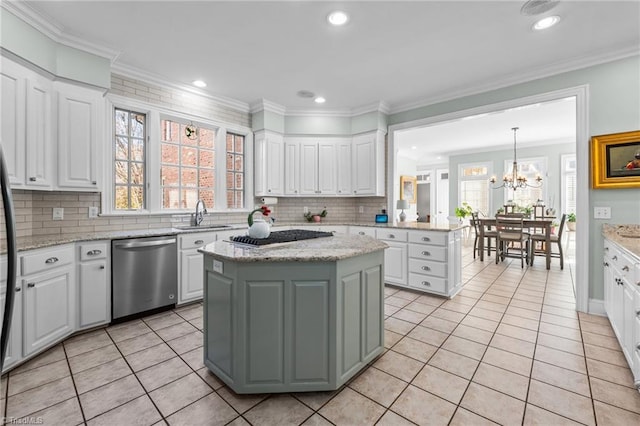 kitchen featuring decorative light fixtures, light tile patterned floors, appliances with stainless steel finishes, a kitchen island, and white cabinets