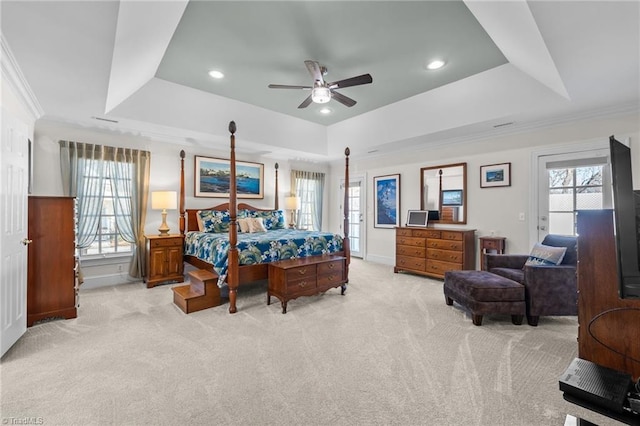 bedroom with light carpet, ornamental molding, a raised ceiling, and ceiling fan