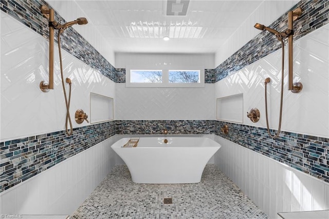 bathroom featuring tile walls and a bathtub