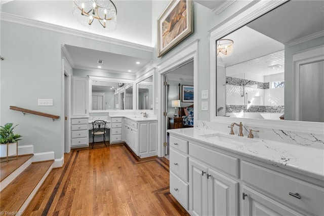 bathroom featuring crown molding, hardwood / wood-style floors, vanity, a shower with shower door, and a chandelier