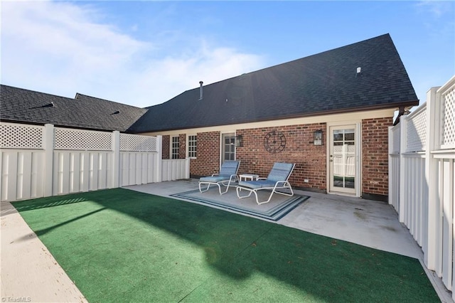 back of house with a yard and a patio