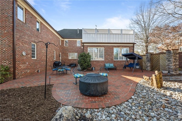 rear view of house with a balcony, an outdoor fire pit, and a patio area