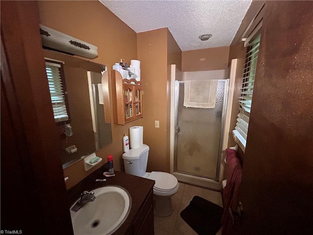 bathroom featuring tile patterned flooring, vanity, an enclosed shower, toilet, and a textured ceiling