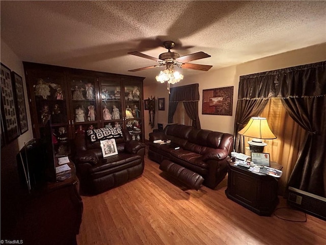 living room featuring ceiling fan, a textured ceiling, and light hardwood / wood-style flooring