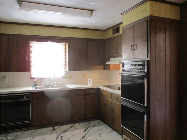 kitchen featuring visible vents, black appliances, under cabinet range hood, a sink, and wallpapered walls