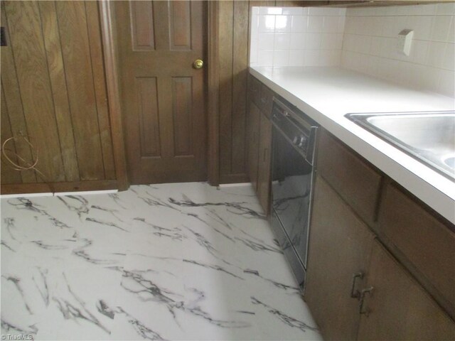 kitchen with dishwasher, light countertops, brown cabinets, and a sink