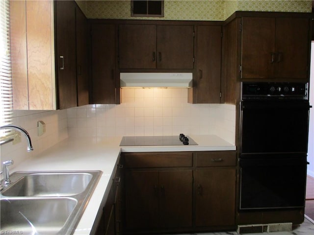 kitchen featuring range hood, visible vents, a sink, decorative backsplash, and black appliances
