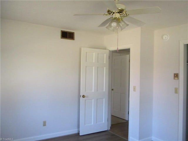 unfurnished bedroom with visible vents, a ceiling fan, baseboards, and dark wood-style flooring